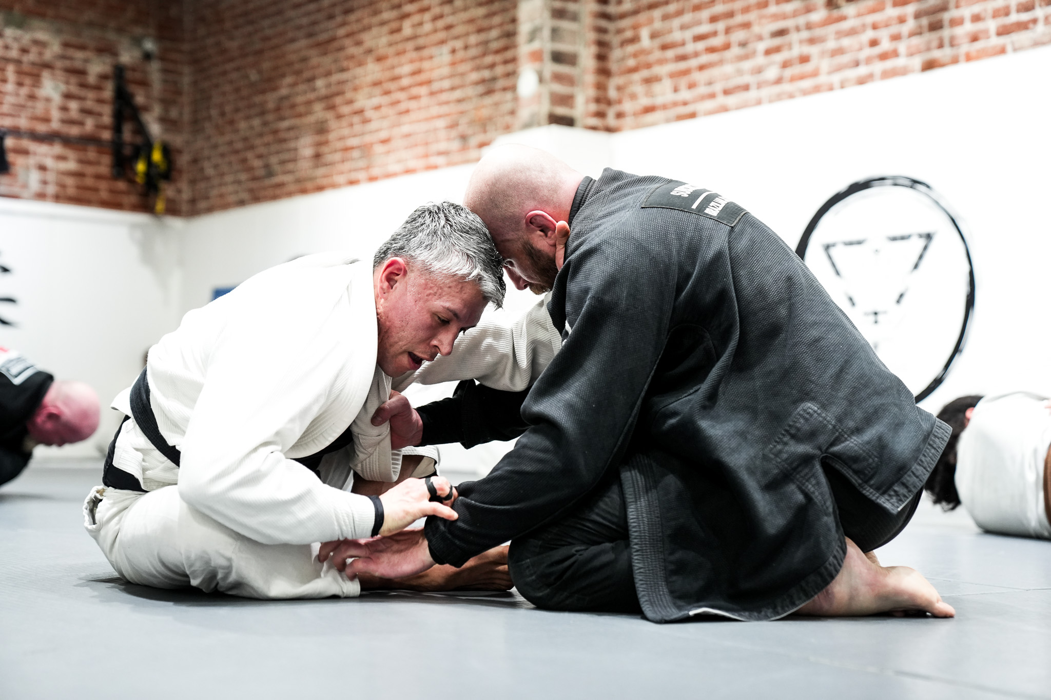 BJJ black belts rolling at Subconscious Jiu Jitsu Association academy — serious training environment